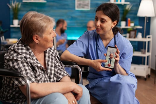 Nurse assisting senior patient with online consultation