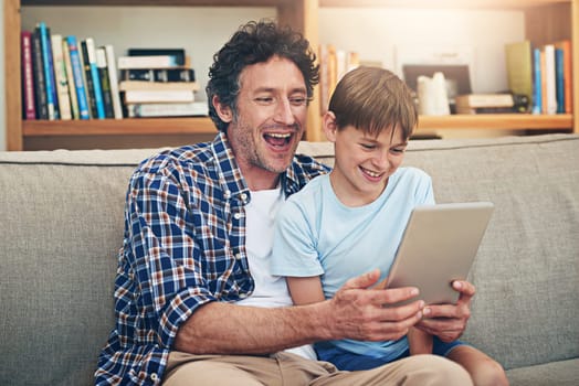 So many hilarious clips to tickle the funny bone. a happy father and his son using a digital tablet together at home.