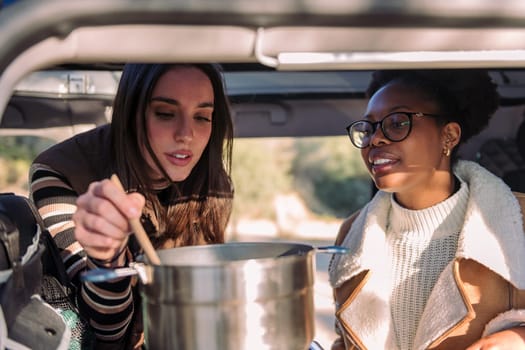women in a road trip travel cooking in camper van