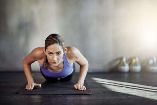 The next level of fitness. an attractive young woman doing pushups as part of her workout.