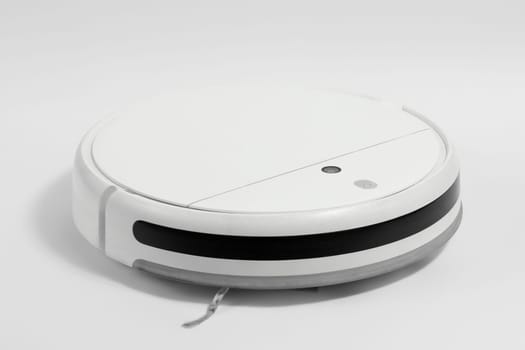 White robot vacuum cleaner with a brush on a white background