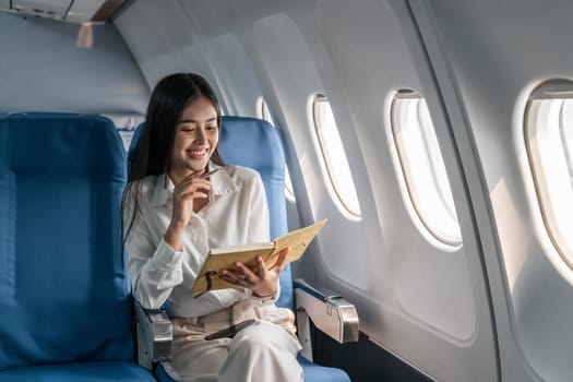 Asian female thinking about work in airplane concept Business traveling and technology concept