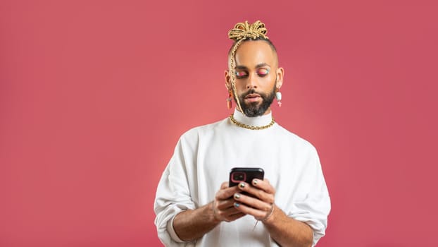 Black latin gay man with smartphone isolated on pink background