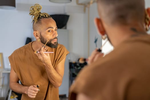 Black male gay applying make up