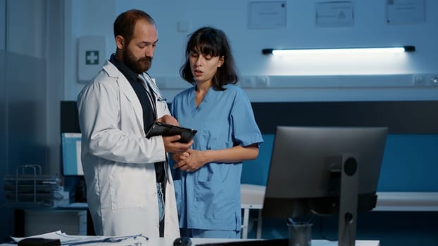 Nurse and doctor looking at medical expertise on tablet computer