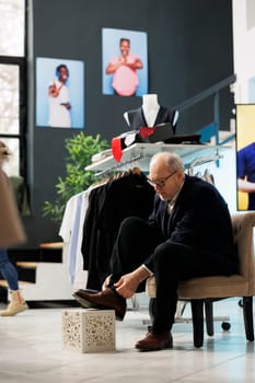 Senior customer trying elegant shoes in modern boutique