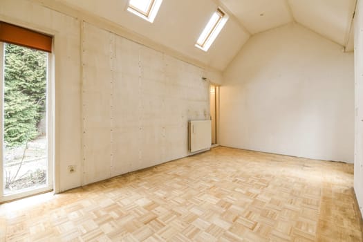 an empty room with a wood floor and a window