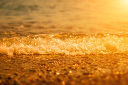 Abstract nature summer ocean sunset sea background. Small waves on water surface in motion blur with bokeh lights from sunrise. Holiday, vacation and recreational background concept