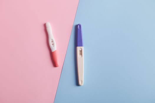 Pregnacy tests with positive reults, isolated bicolor pink and blue background. Pregnany and planning maternity concept