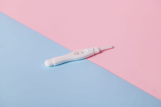 Inkjet pregnancy test with two bars, isolated bicolor pink and blue background. Women's health and Planning maternity