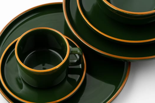 A set of dark green ceramic tableware with orange outlines