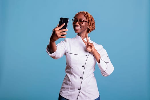 Young african american chef taking selfie