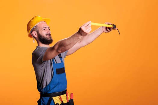 Confident construction worker using tape measure