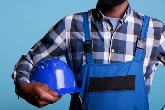 Construction worker holding protective helmet