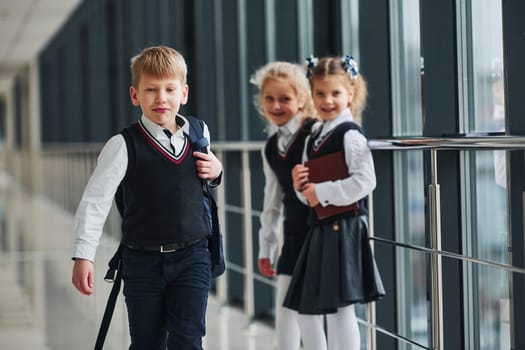School kids in uniform together in corridor. Conception of education