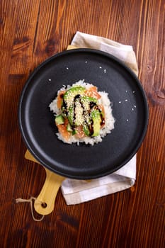 Sushi waffle is a cooking process. Culinary trend made with crispy rice waffles and sprinkled with salmon. Vertical photo