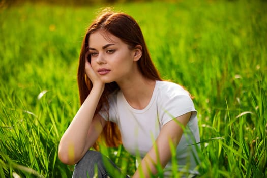 Beautiful young woman close up portrait among green cereal grass
