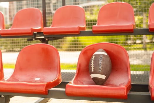American football ball on the tribune of the stadium