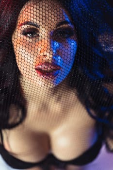 portrait of a beautiful sexy brunette woman through lace