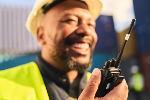 Delivery, shipping and construction worker talking on radio in shipyard. Black man with walkie talkie for communication in logistics, distribution and import and export business with cargo container.