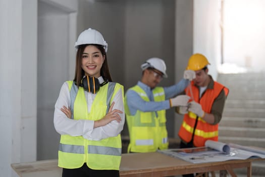 Portrait, construction worker and building with a woman engineer standing arms folded at site work