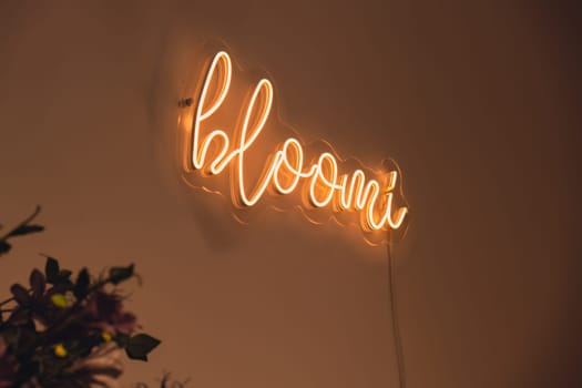 BLOOMI inscription in neon lights at night. Electric sign at night nightlife concept. Modern fluorescent life style luminescent. LED light