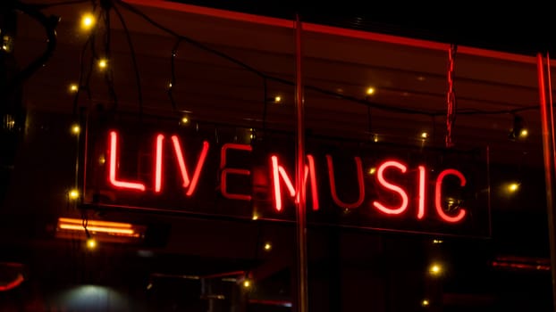 Live music inscription in neon lights at night. Electric sign at night nightlife concept. Modern fluorescent life style luminescent. LED light sign text