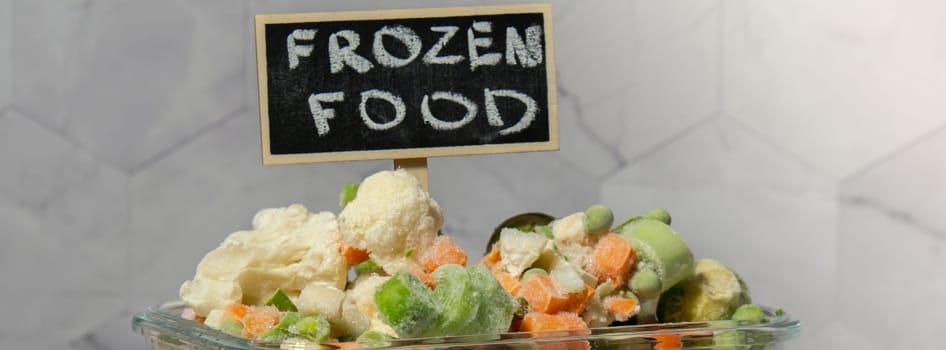 Frozen mixed vegetables for long-term storage with blackboard label and text FROZEN FOOD. Deep freezing of vegetables. defrosting Frozen food background