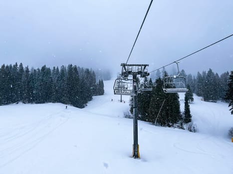 Ski Lift snowy mountain winter forest with chair lift At The Ski Resort in winter. Snowy weather Ski holidays Winter sport and outdoor activities Outdoor tourism