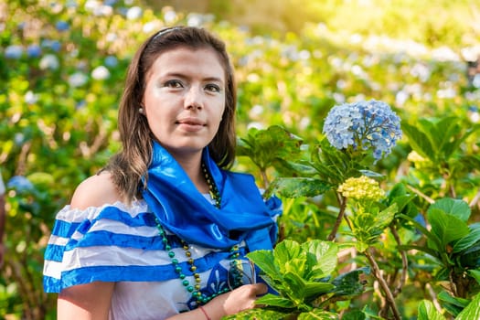 Portrait of smiling woman in national folk costume in a field of flowers. Nicaraguan national folk costume, Young Nicaraguan woman in traditional folk costume in a field of Milflores