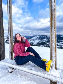Shot of a skier woman sitting on the ski slope resting relaxing extreme recreation active lifestyle activity. Female skier on a slope in the mountains. Winter active sport