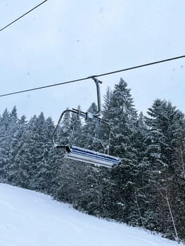 Ski Lift snowy mountain winter forest with chair lift At The Ski Resort in winter. Snowy weather Ski holidays Winter sport and outdoor activities Outdoor tourism