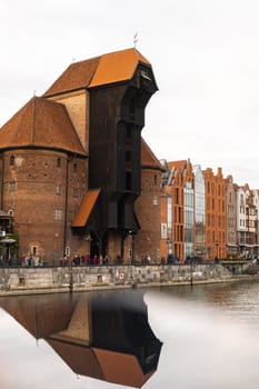 Ancient crane - zuraw Old town in Gdansk. The riverside on Granary Island reflection in Moltawa River. Visit Gdansk Poland Travel destination. Tourist attraction