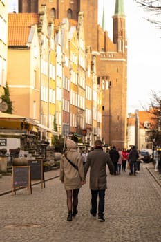 Gdansk Poland May 2022 couple of tourists walking in City hall at Square Travelers discover Ancient architecture of old town in Gdansk Poland. Travel destination