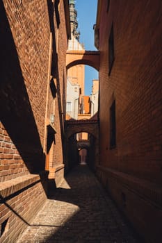 Elblag, Poland. Medieval alleyway in Old Town of Elblag city in Poland. Narrow cobblestone passage between tenement houses called The Church Path. View of City of Architecture famous popular tourist attraction travel destination Elblag. Museums and monuments Europe