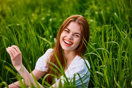 portrait of laughing woman sitting in tall grass