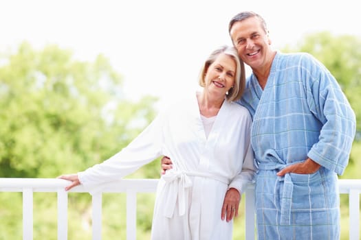 Mature couple in bathrobes enjoying their retirement vacation. Cute mature couple in bathrobes enjoying their retirement vacation.