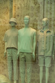 Shop windows and three male mannequins showing casual fashion in store mall market. Faceless in fashionable clothes Fashion Store exterior. Boutique. Front View from street outdoor.