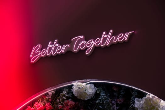 BETTER TOGETHER inscription in neon lights at night. Electric sign at night nightlife concept. Modern fluorescent life style luminescent. LED light sign text
