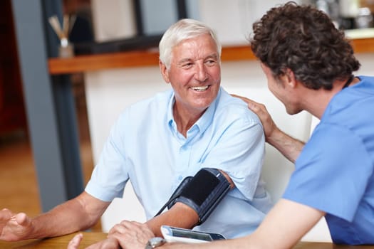 Hes a supportive healthcare professional. a doctor checking a senior patients blood pressure