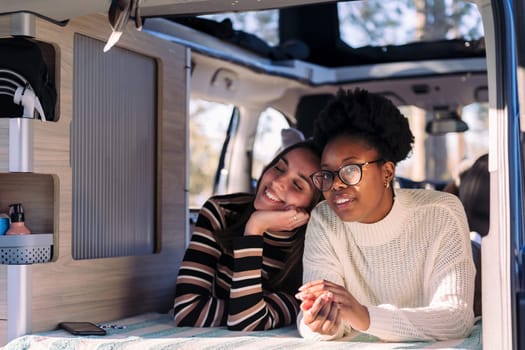 two adventurous young women relaxing in camper van