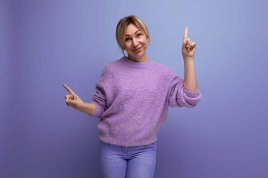 portrait of energetic charming cute blondie woman in lavender sweater on purple background with copy space