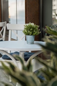 Outdoor table in street cafe. Outdoor empty coffee and restaurant terrace with potted plants tables and chairs in london indie and hipster style. Travel concept