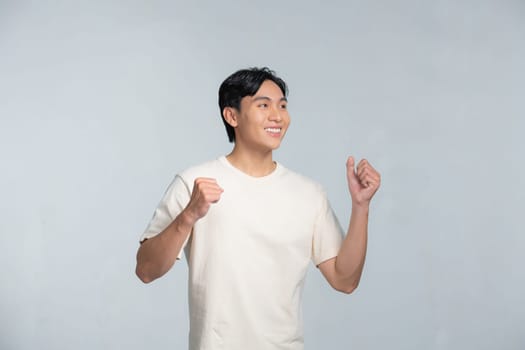 A portrait of happy excited young Asian man isolated on white background