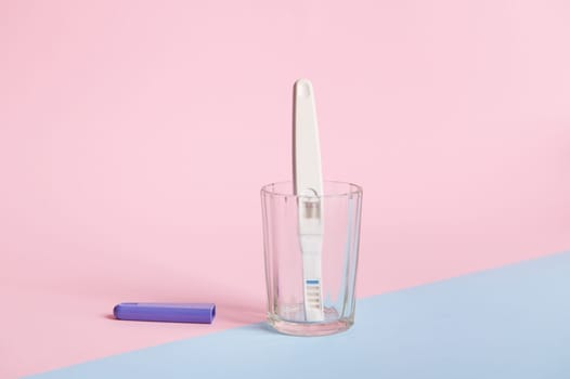 Still life. Pregnancy test with two bars, isolated bicolor pink and blue background. Women's health. Planning maternity
