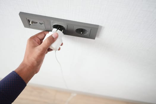 white color power cord cable plugged into wall