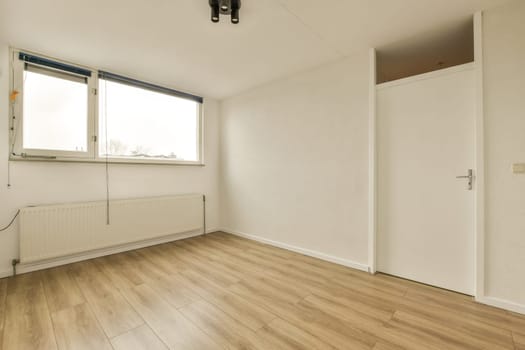 an empty room with white walls and wooden flooring