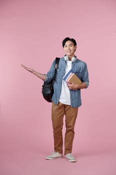 Young student man isolated on pink background extending hands to the side for inviting to come