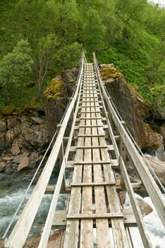 Suspension bridge in Norway. A narrow suspension bridge in mountain area in the northern part of Norway, Nordland.