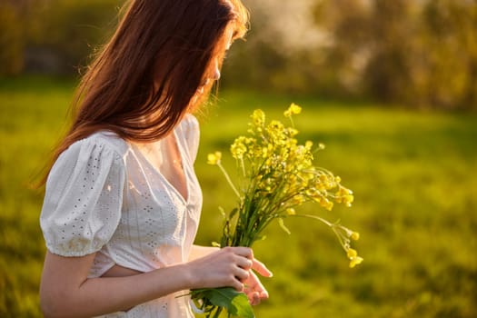 portrait of a woman with a bouquet of wild flowers in the rays of the setting sun in a field